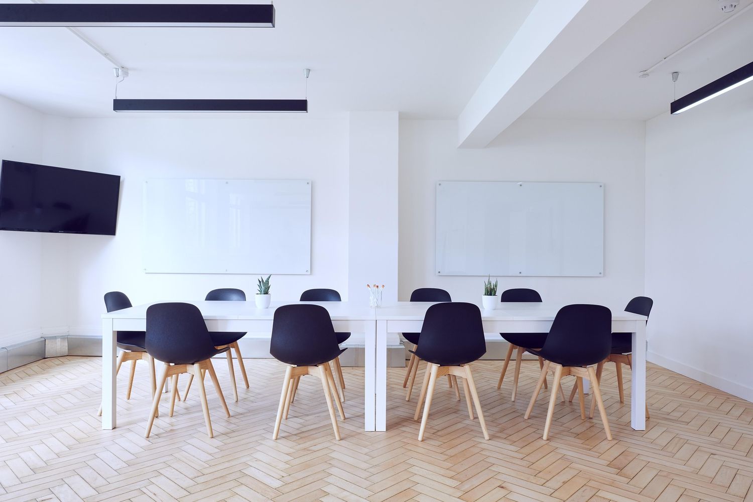 Salle de formation claire, tables et tableaux blancs